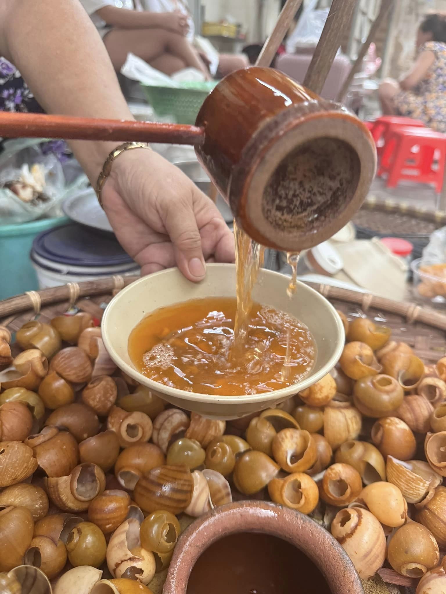 Đôi quang gánh bún ốc nguội với chum gốm đựng nước dùng và những con ốc tươi ngon