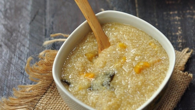 Mô tả hình ảnh: Lợi ích tuyệt vời của hạt kê đối với sức khỏe, thể hiện qua một bát cháo kê và một muỗng gỗ