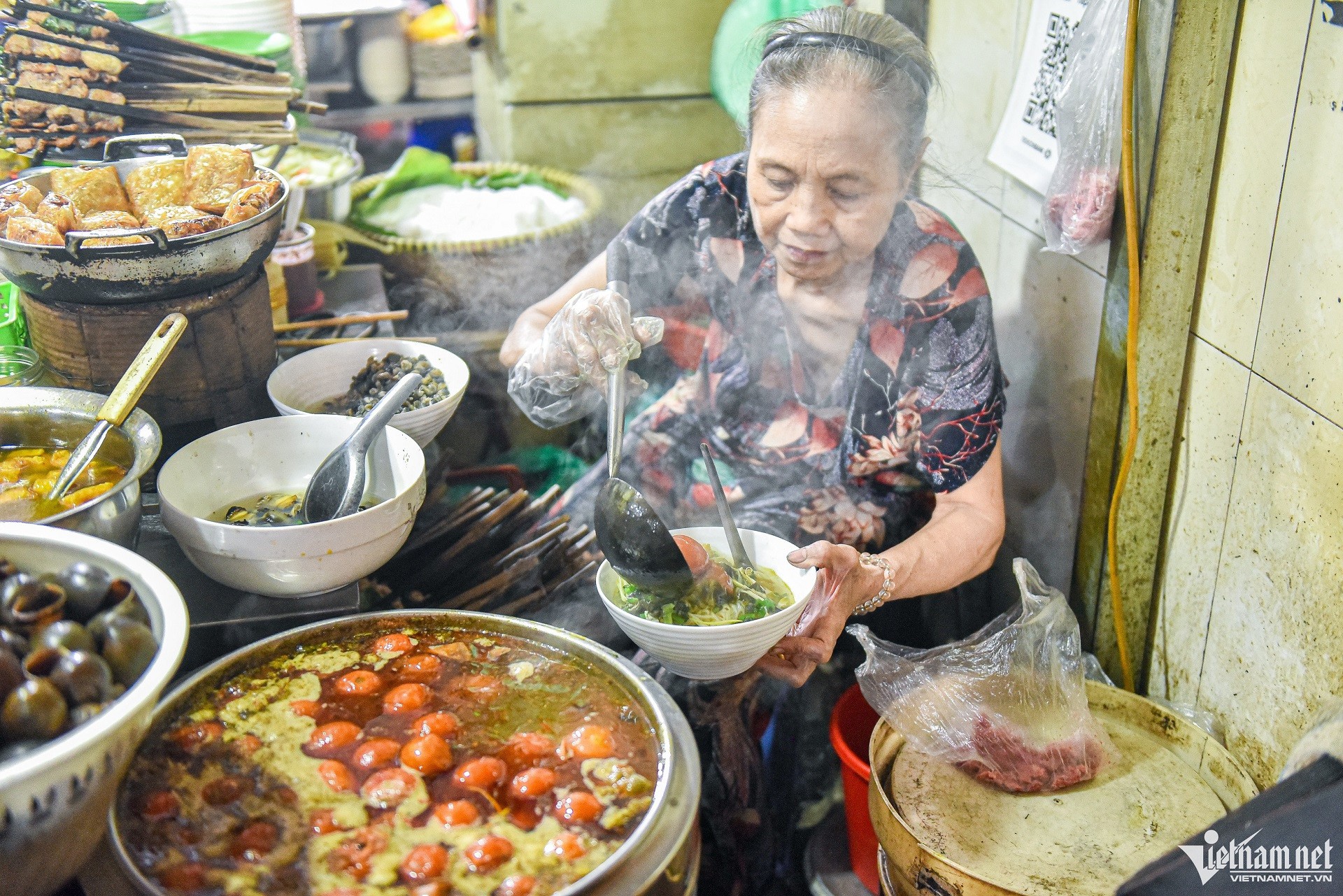 Nồi nước dùng bún ốc hấp dẫn với cà chua, ớt và riêu cua tại ngõ chợ Đồng Xuân